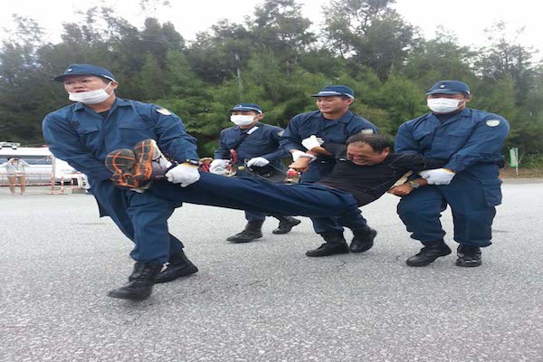 | Japanese police carrying away a protestor Photo Eliza Egret | MR Online