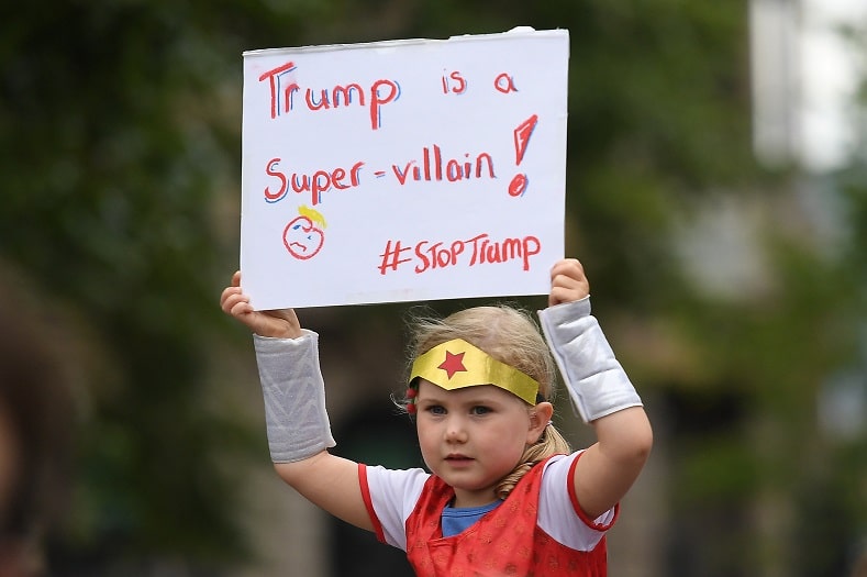 | A young demonstrator holds a banner objecting to the visit of US President Donald Trump to the United Kingdom in Belfast | MR Online