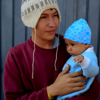 Jose Pedro Rosales Fernandez, 18, from Progreso, Honduras, holds his four-month-old son Dariel, inside the sports complex where thousands of migrants have been camped out for several days in Mexico City, Nov. 9, 2018. Rebecca Blackwell | AP