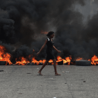 If you don’t let us breathe, we won’t let you breathe. Port-au-Prince, Haiti, 2019. (Photograph: Hector Retamal.)