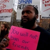 Isaiah Dupree holds a sign as demonstrators gather at Washington Square Park to protest against U.S. President Donald Trump in New York U.S., January 25, 2017. REUTERS/Shannon Stapleton - RTSXDZB