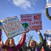 School children hold placards and shout slogans as they participate in the Strike for Climate Change protest