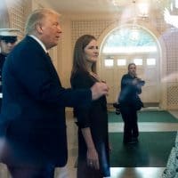 In an image taken through a window, President Donald Trump, left, and Judge Amy Coney Barrett, walk through the Palm Room after announcing Barrett as his nominee to the Supreme Court, in the Rose Garden at the White House, Saturday, Sept. 26, 2020, in Washington. Alex Brandon | AP