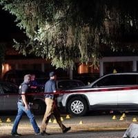 Police walk past evidence markers at a scene Thursday, Sept. 3, in Lacey, Wash., where Michael Reinoehl, 48, was killed by a federal task force. (AP Photo/Ted Warren)