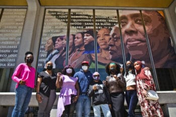 | From left Dr Ala Stanford Ajeenah Amir Sajda Purple Blackwell artist Russell Craig Pam Africa Krystal Strong YahNé Ndgo and Kezia Ridgeway stand in front of the East side of the Crown mural that pays homage to their social justice work at Philadelphias Municipal Services Building Photo Kimberly Paynter WHYY | MR Online