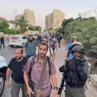 ARMED ISRAELI SETTLERS ARRIVING IN LYDD (LOD) WITH PROTECTION FROM ISRAELI FORCES, MAY 12, 2021. (PHOTO: TWITTER)