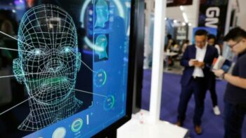 | Visitors check their phones behind the screen advertising facial recognition software during the Global Mobile Internet Conference GMIC at the National Convention in Beijing China April 27 2018 Source priorg | MR Online