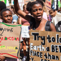 11th Grader Zenile Ngcame of Masiphumelele High School raises her fist during a 2019 protest for action against climate change outside Parliament in Cape Town.