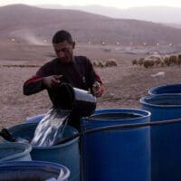 | A Palestinian farmer fills water tanks in the West Bank village of Khirbet al Makhoul Jordan Valley October 9 2013 Activestillsorg | MR Online