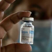 Cuban health worker holding vial of Abdala vaccine.