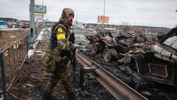 | An armed man stands by the remains of a Russian military vehicle in Bucha close to the capital Kyiv Ukraine Tuesday March 1 2022 AP PhotoSerhii Nuzhnenko | MR Online