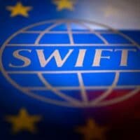 | Swift logo is pictured with EU and Russian flags in this illustration picture taken February 26 2022 | MR Online