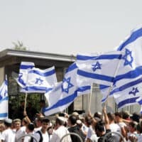 ISRAELI SETTLERS WAVE ISRAELI FLAGS NEAR DAMASCUS GATE DURING THE ‘FLAG MARCH’ IN JERUSALEM ON MAY 29, 2022. (PHOTO: JERIES BSSIER/APA IMAGES)