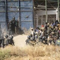 Riot police cordon off area after people crossed fences separating the Spanish enclave of Melilla from Morocco (Javier Bernardo/AP)