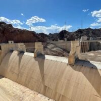 A giant spillway at Hoover Dam gathers gravel and other debris instead of water, as seen on June 28, 2022. The dam has two of these concrete-lined open channels, designed to help funnel overflowing water from Lake Mead around Hoover Dam and out into the Colorado River. The spillways haven’t seen any overflow since the summer of 1983. (Image source: © Tom Yulsman via waterdesk.org))