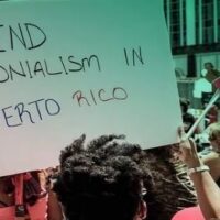 Protesters in Puerto Rico raise a banner demanding an end to US colonization of the island. Photo: Progressive International.