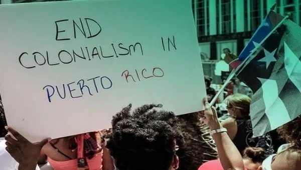 | Protesters in Puerto Rico raise a banner demanding an end to US colonization of the island Photo Progressive International | MR Online