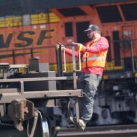 A worker rides a rail car at a BNSF rail crossing in Saginaw, Texas, Wednesday, Sept. 14, 2022. [AP Photo/LM Otero]