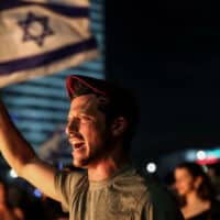 A PROTESTER IN MILITARY PARAPHERNALIA SHOUTS SLOGANS DURING A MASS ANTI-GOVERNMENT PROTEST FOLLOWING BENJAMIN NETANYAHU’S DISMISSAL OF DEFENSE MINISTER YOAV GALANT. (PHOTO: ILIA YEFIMOVICH/DPA VIA ZUMA PRESS/APAIMAGES)