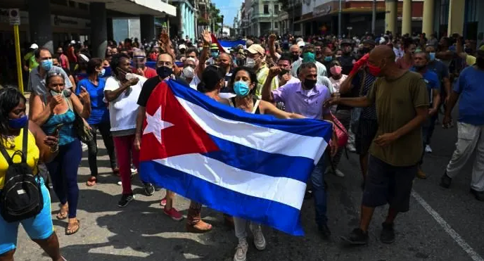 | The Washington Post featured this photo as an example of anti government protests but it is clearly a pro government rally in which the demonstrators are waving the Cuban flag in solidarity with the Cuban Revolution The man behind the flag in the baseball cap is Gerardo Hernández a well known leader of the Committees for the Defense of the Revolution member of the Central Committee of the Cuban Communist Party and one of the Cuban 5 who spent 16 years in prison in the US framed for his work helping to stop terrorist attacks against the Cuban people Source washingtonpostcom | MR Online