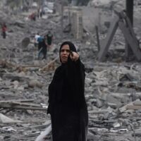 Palestinians walk through debris amid the destruction from Israeli airstrikes in Gaza City's al-Rimal neighbourhood on 10 October, 2023 (AFP)