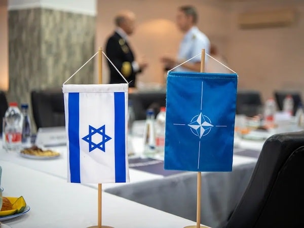 | A NATO and an Israeli table side flags on a blurred buffet table and two military officers talking Photo NATO Maritime CommandFile photo | MR Online