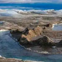 Drainage system with dirt cone on the surface of the ice sheet. The brown sediment on the ice is created by the rapid melting of the ice. Landscape of the Greenland ice sheet near Kangerlussuaq. (Martin Zwick/REDA&CO/Universal Images Group via Getty Images)