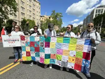 | Formerly incarcerated New Yorkers holding a quilt with names of those seeking clemency | MR Online