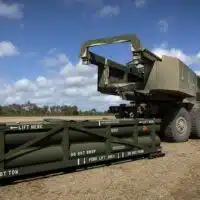 A US Army soldier prepares the crane for loading the Army Tactical Missile System (ATACMS) on to the High Mobility Artillery Rocket System (HIMARS) in Queensland, Australia, July 26, 2023. [AP Photo/Sgt. 1st Class Andrew Dickson]