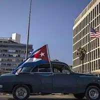 | A classic American car flying a Cuban flag drives past the US embassy during a rally calling for the end of the US blockade against Cuba Photo APRamon Espinosa | MR Online