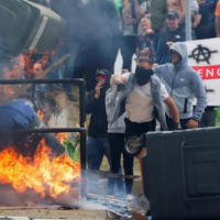 Protestors throw a blazing garbage bin outside the Holiday Inn Express in Rotherham on Sunday.Stringer/Reuters